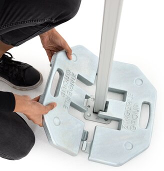 The woman attaches the 28 kg base plate to the folding gazebo.